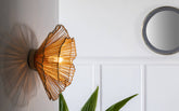 Klimt Cane Wall Lamp with natural cane shade on an abstract mild steel frame. Impressionism-inspired design for a unique decorative wall light